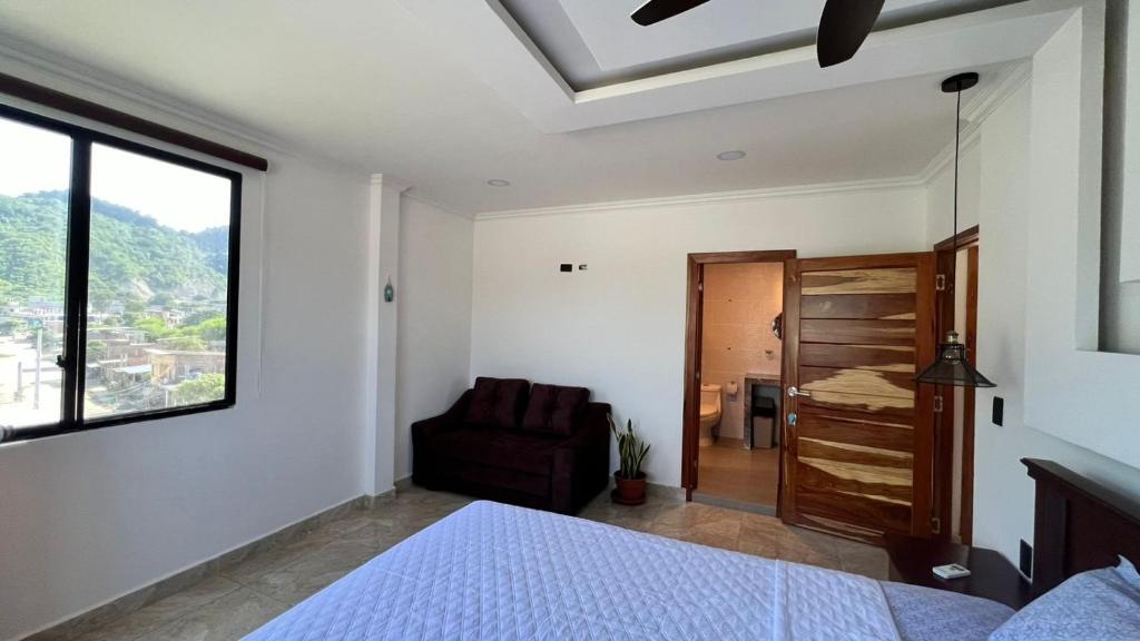 1 dormitorio con 1 cama, 1 silla y 1 ventana en Residencia Vigonza, en Puerto López