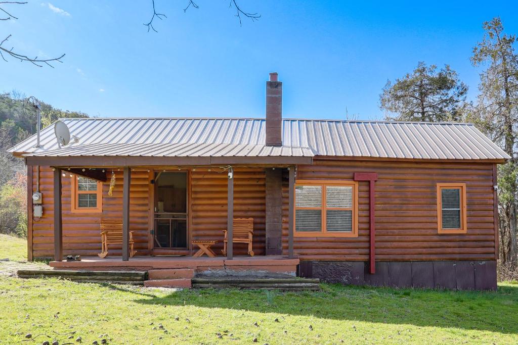 a log cabin with a porch and a chimney at Serene Guion Cabin Less Than 1 Mi to the White River! in Guion
