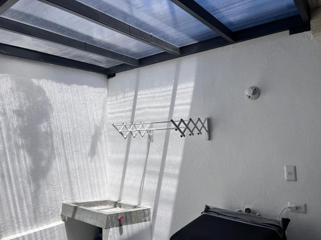 baño con ventana, lavabo y aseo en Casa excelente (Llano Chico), en Quito