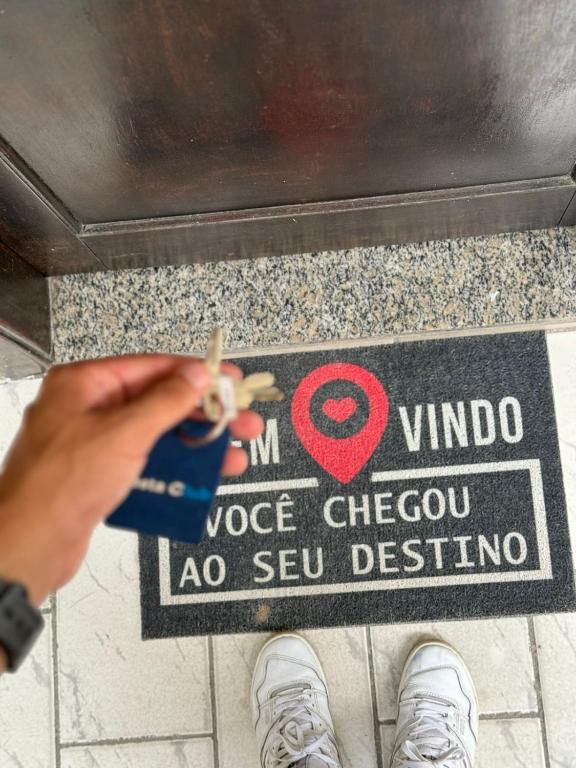 una persona che taglia un cartello su un pavimento con delle forbici di Linda Kitnet mobiliada a São Vicente