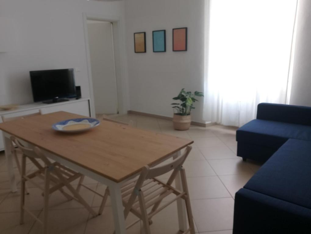 sala de estar con mesa y sofá azul en Casa Cavour, en Livorno