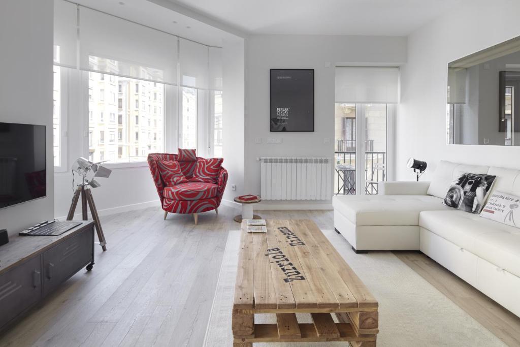 Sala de estar con sofá blanco y mesa de centro en Zurriola Zinema by FeelFree Rentals, en San Sebastián