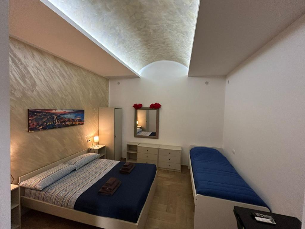 ein kleines Schlafzimmer mit einem Bett und einem Spiegel in der Unterkunft Good Friends Home in Neapel