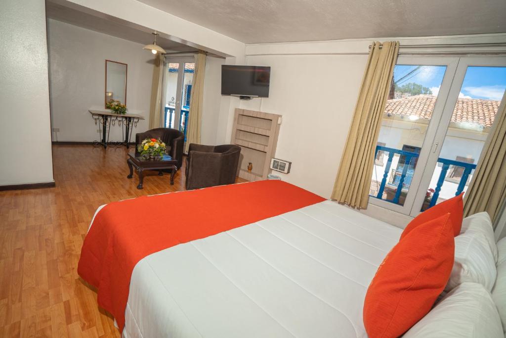 um quarto com uma cama e um quarto com uma televisão em Royal Inka II em Cusco