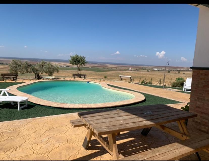 a swimming pool with a picnic table and a bench at Los Alcores , disfruta de la naturaleza ! in Villalba del Alcor