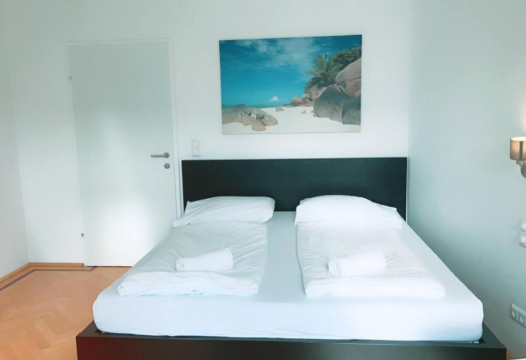 a bed with white sheets and pillows in a room at Quad Room In Keplerplatz in Vienna