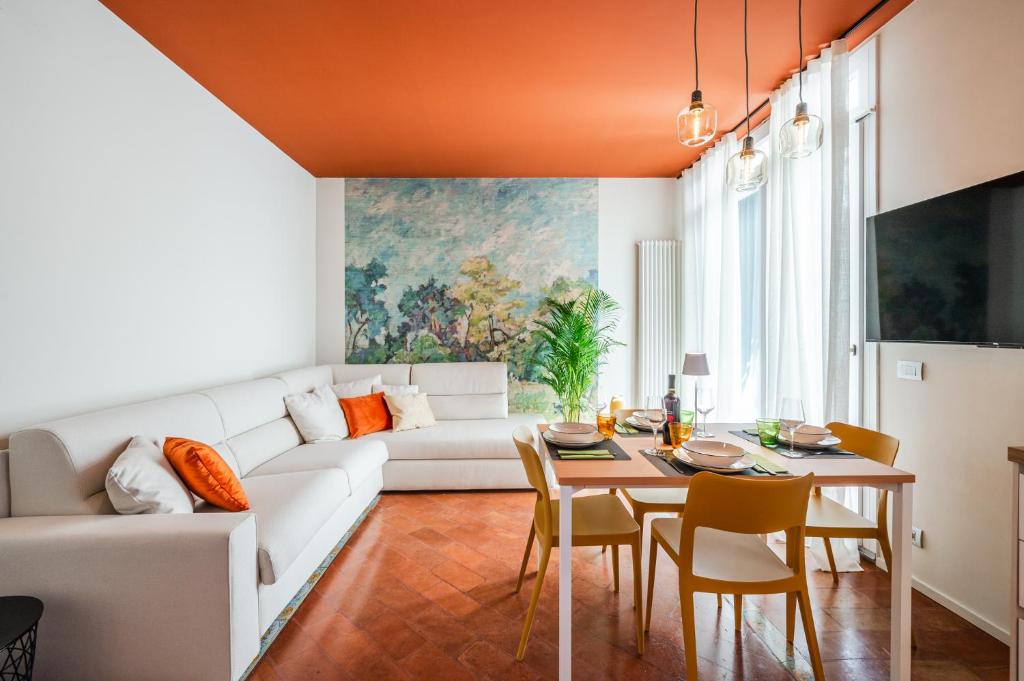 uma sala de estar com um sofá branco e uma mesa em Urban Cottage [Free Parking - Private Garden] em Bolonha