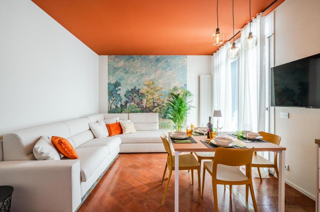 a living room with a white couch and a table at Urban Cottage [Free Parking - Private Garden] in Bologna