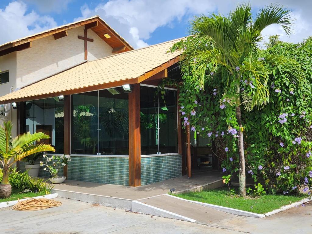 una casa con una palma di fronte di Eventos Villa Garden ad Aracaju