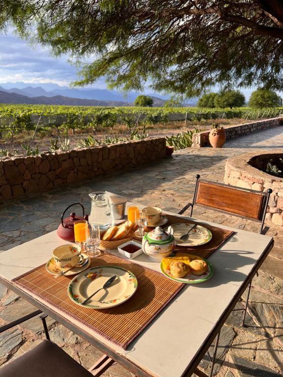 a table with plates of food on it with a view at Chañarmuyo Casa de Huéspedes in Chañarmuyo