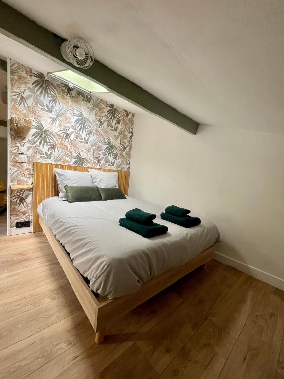 - une chambre avec un lit et 2 serviettes vertes dans l'établissement Sous les toits du parvis, à Niort