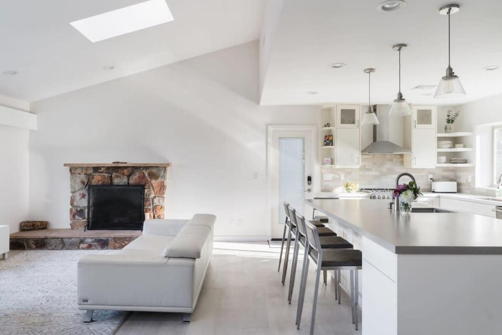 a white kitchen with a fireplace and a table and chairs at Spacious and Bright 5-Bedroom Oasis Pool and Yard in La Mesa