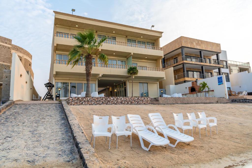 a group of white chairs in front of a building at منتجع الوفاء درة العروس للعائلات فقط in Durat  Alarous