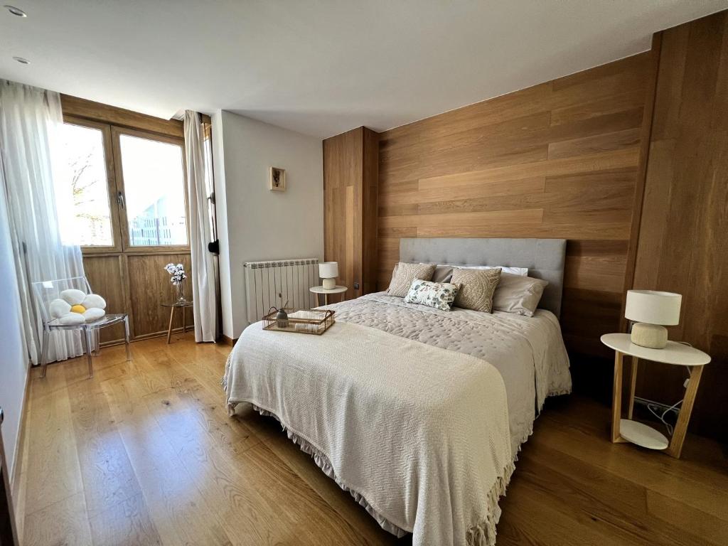 Vitoria-Gasteiz magnífica casa في فيتوريا جاستيز: غرفة نوم بسرير كبير وبجدار خشبي