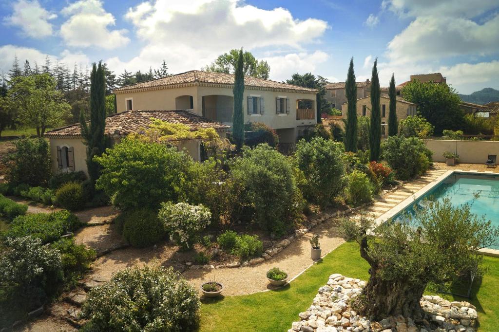 a house with a garden and a swimming pool at Le Mas de Cink in Saint-Saturnin-les-Apt