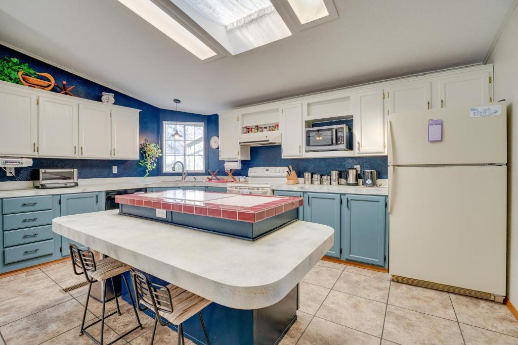 a kitchen with blue cabinets and a white refrigerator at Idyllic Rock Island Home with Columbia River Views 