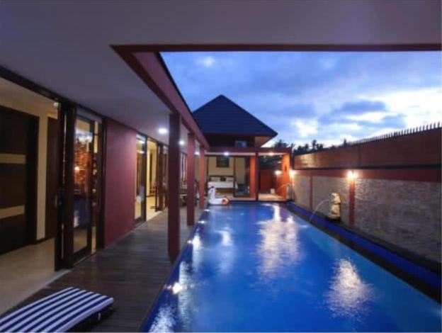 a swimming pool in the middle of a building at Dawn Golf Villa in Tanjung