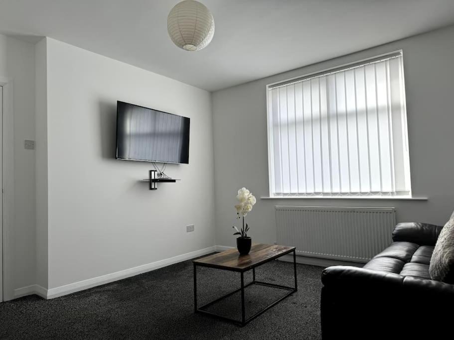 a living room with a couch and a table at Entire 6 bedroom house in Oldham in Moston