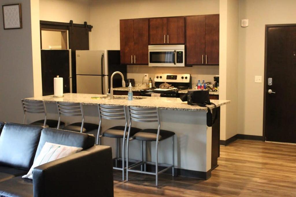 een keuken met een groot eiland met barkrukken bij Spacious 2BR Suite Plus Patio Near Iowa State in Ames