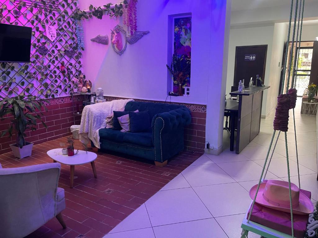 un soggiorno viola con divano e tavolo di Hotel House a Medellín