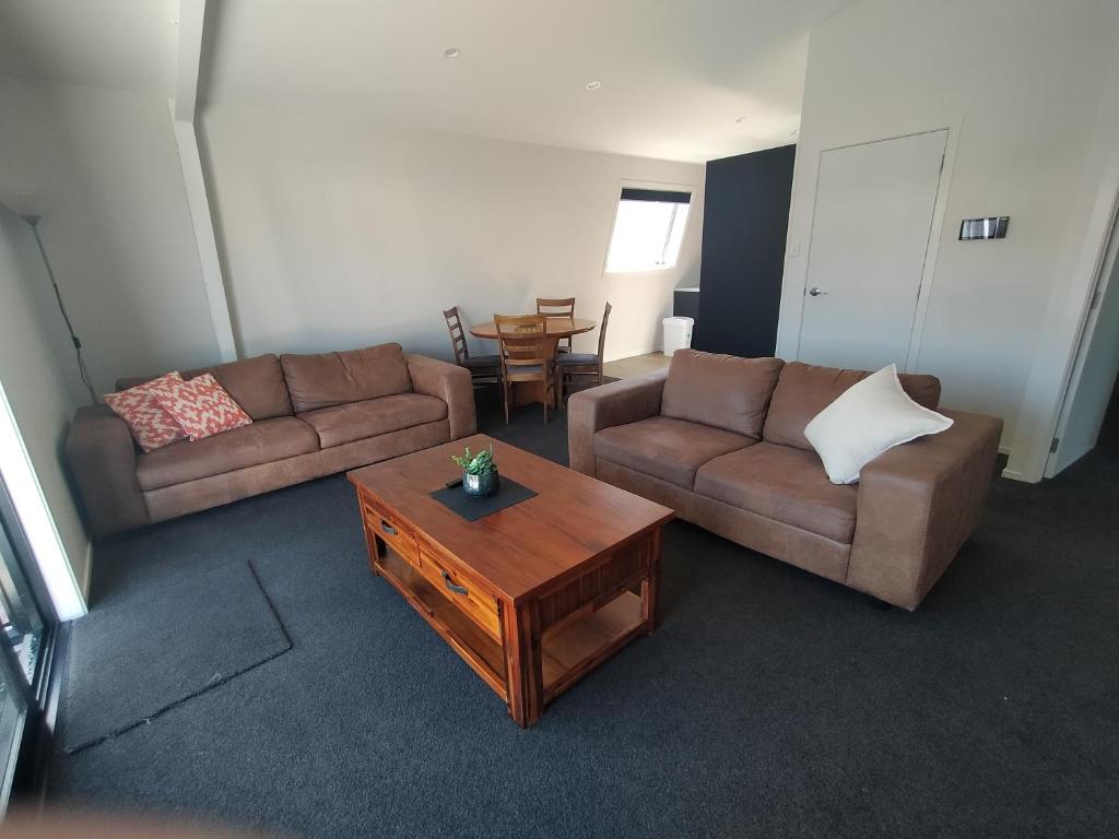 uma sala de estar com dois sofás e uma mesa de centro em 117 Leith St em Dunedin