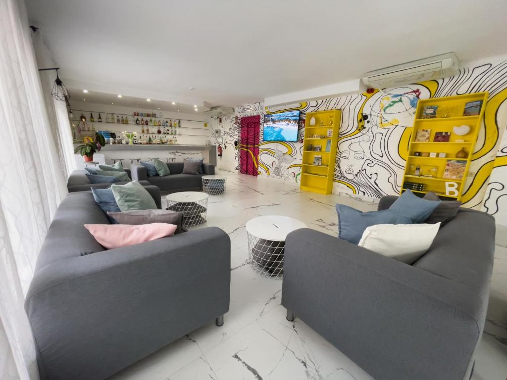 a living room with couches and tables and a mural at Hotel Maremagnum in Lloret de Mar