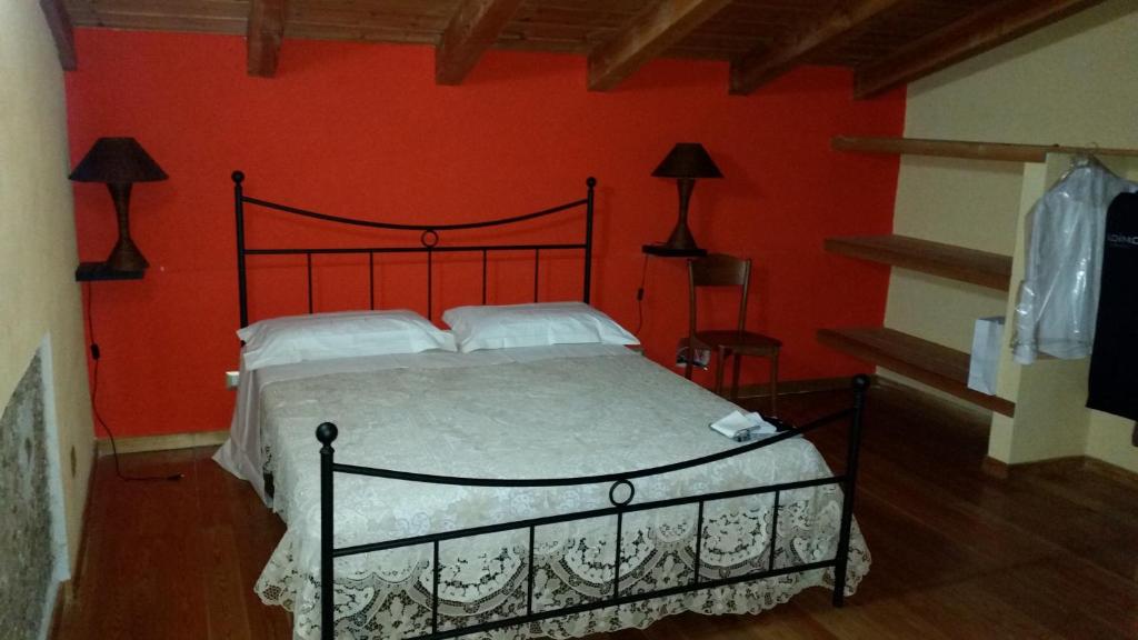 una camera da letto con un letto con una parete rossa di Agriturismo Pietro Falcone a Celico