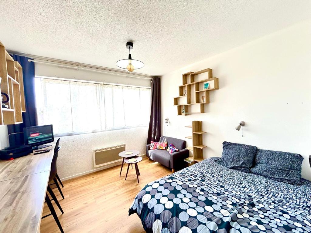 une chambre avec un lit, une télévision et un canapé dans l'établissement Studio MAJA proche des plages + parking, à Saint-Nazaire