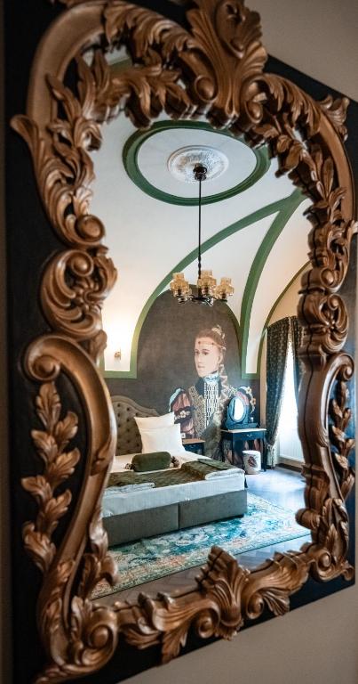 a mirror with a person standing in a bedroom at VICTORIAN HOUSE in Sibiu