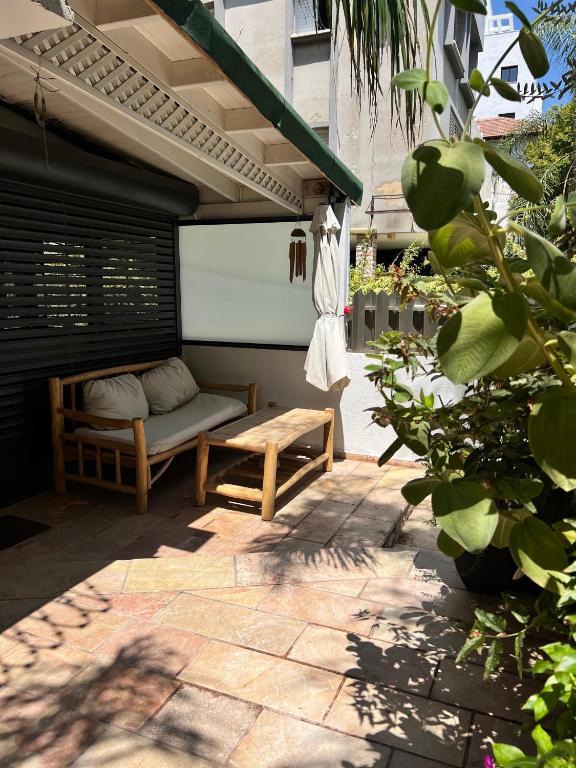 a patio with a bed and a bench on a patio at Saloniky Garden in H̱olon