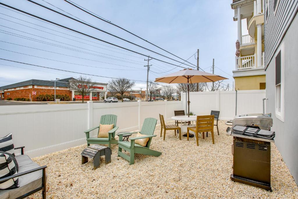 un patio con mesa, sillas y sombrilla en The Kraken Wildwood Townhome half Mi to Beach! en Wildwood