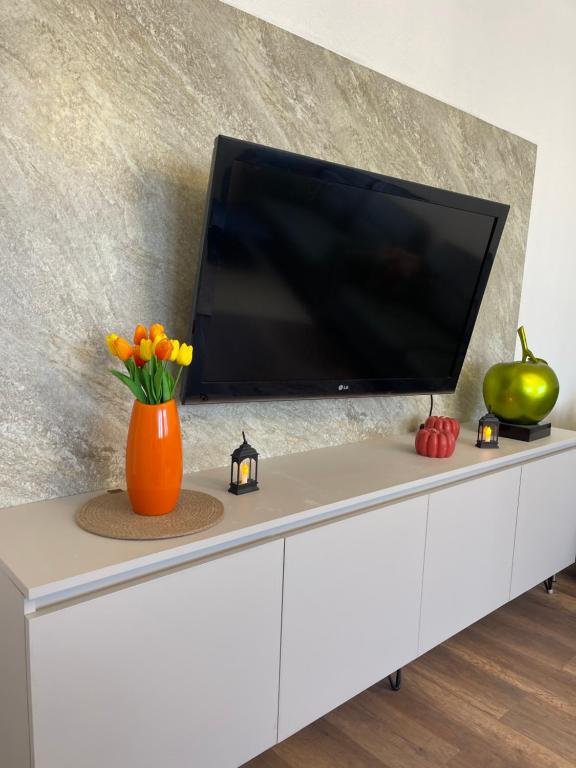 a tv on top of a white cabinet with a television on it at Center apartment in Gjilan