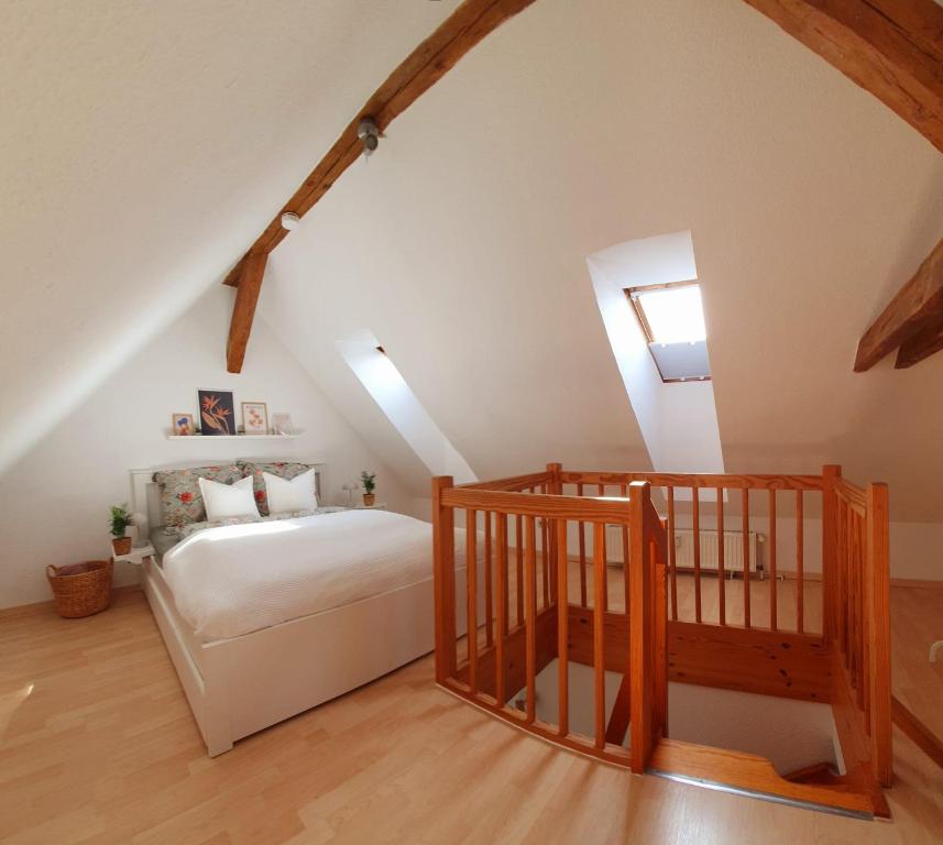 un dormitorio en el ático con una cama y una escalera en Charmante Maisonnette-Dachgeschosswohnung in zentraler Lage, en Rostock