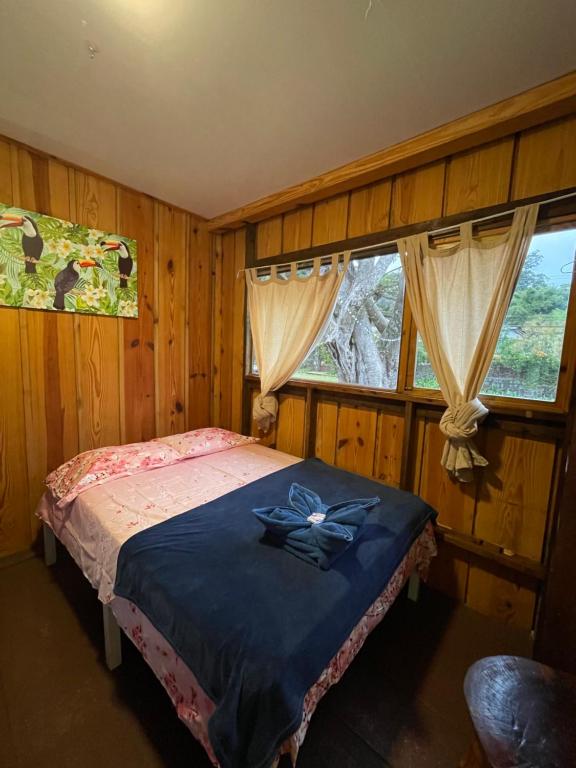 a bedroom with a bed with a blue blanket at Hostal Vista Boquete in Bajo Boquete