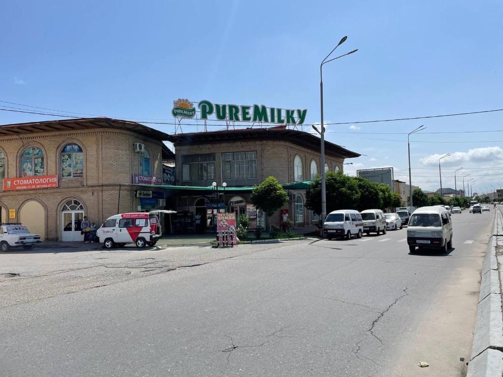 a parking lot with cars parked in front of a store at MIRKA HOTEL LUX in Samarkand