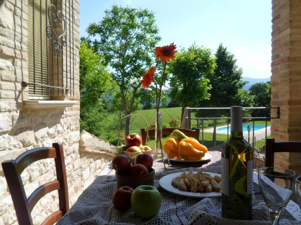 - une table avec un bouquet de fruits et une bouteille de vin dans l'établissement Ferienwohnung Sonnenblumen, à Cagli