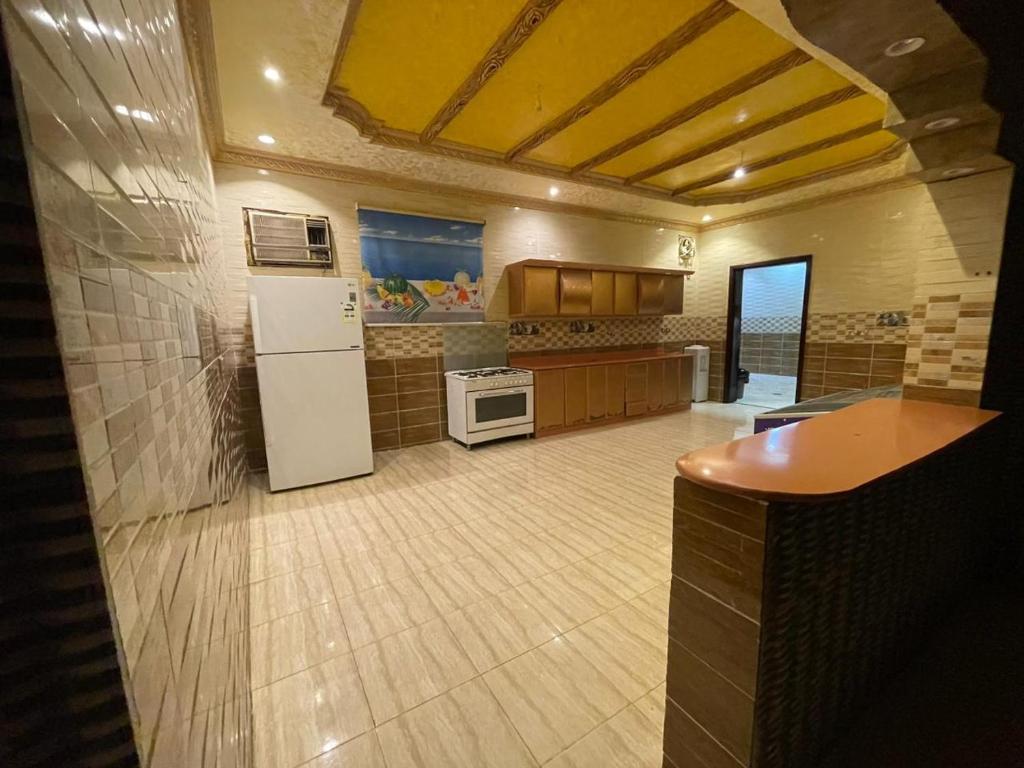a large kitchen with a refrigerator and a stove at شالية الفوز in Medina