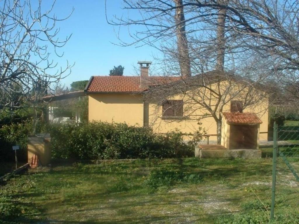 una casa gialla con cortile di Ferienhaus in Cecina mit Großem Garten a Cecina