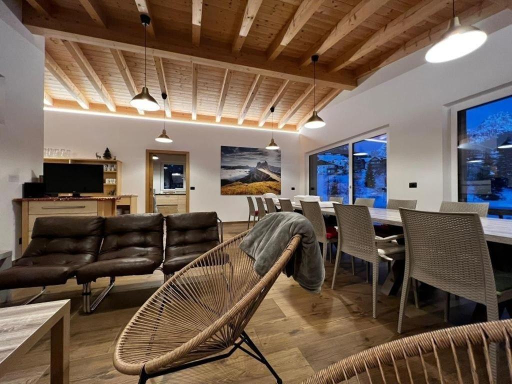 a living room with a couch and a table and chairs at Chalet im Grünen in den Suedtiroler Dolomiten mit 17 Betten in Selva di Val Gardena