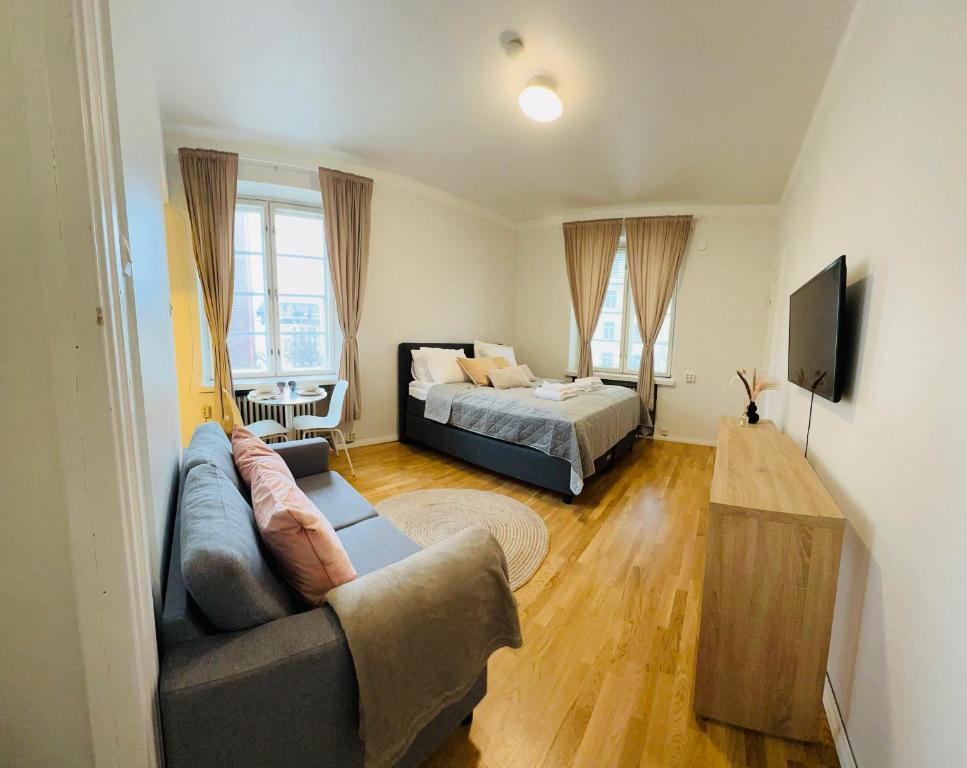 Your Chic Vibrant Airbnb في هلسنكي: غرفة معيشة مع أريكة وسرير