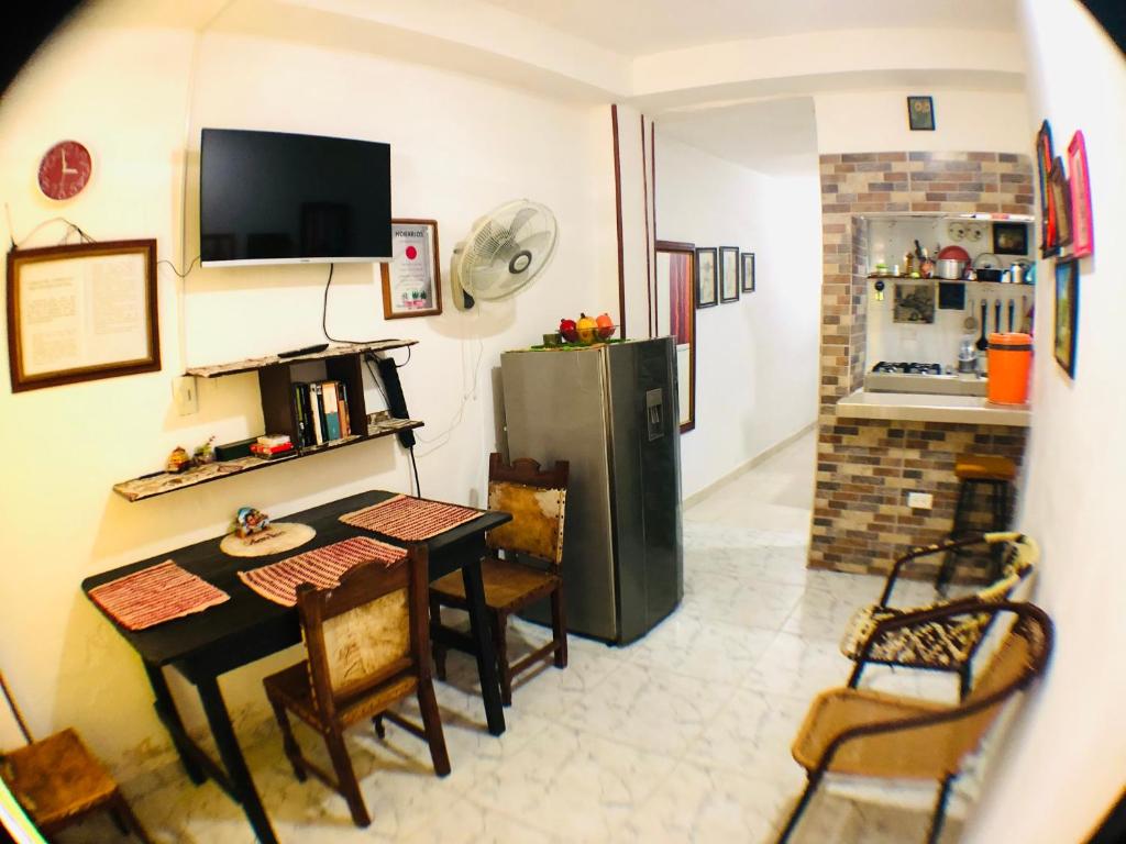 uma sala de estar com uma mesa e um frigorífico em AptoPuntoCentro Santa Marta em Santa Marta