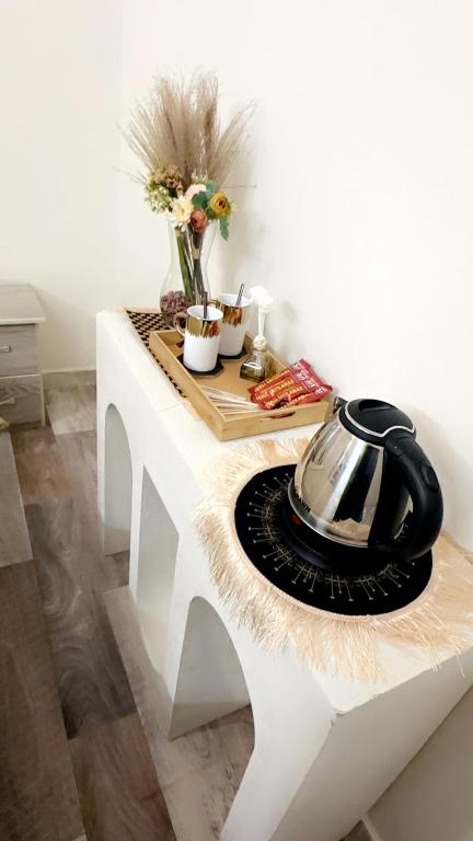 uma mesa branca com uma chaleira para chá em غرفه em Hail