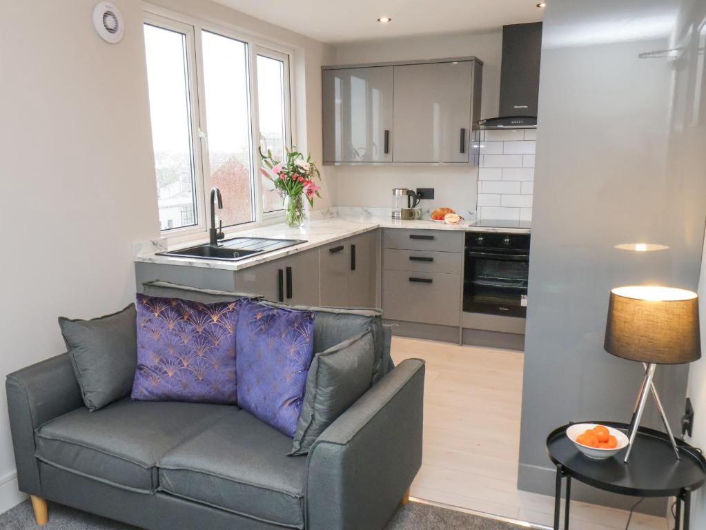 a living room with a couch and a kitchen at Apt 9 Hunter's Quay in Bridlington