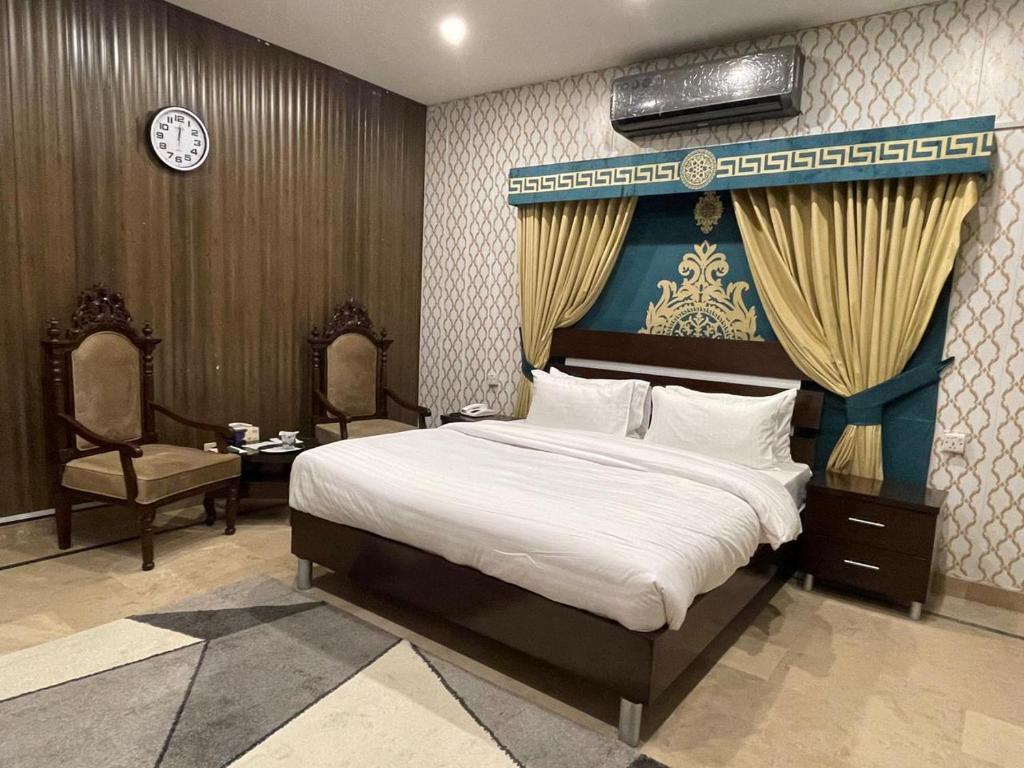 1 dormitorio con 1 cama grande con dosel azul en Trail Residency en Islamabad