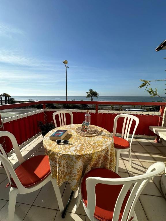 une table et des chaises sur un balcon avec vue sur l'océan dans l'établissement Spacious family nest facing the sea, à La Baule