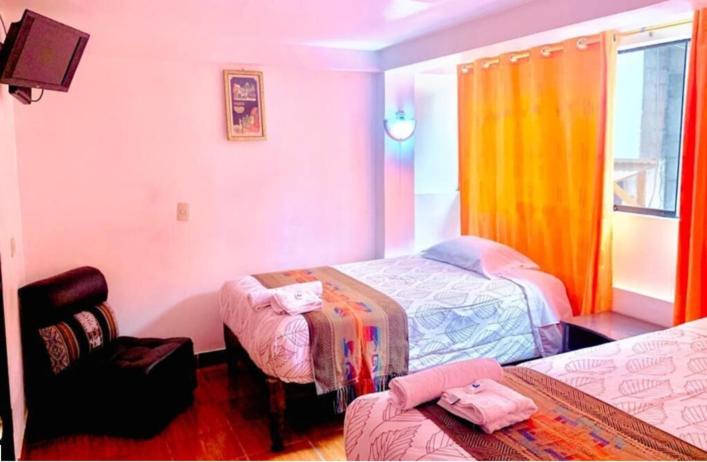 Pokój hotelowy z 2 łóżkami i krzesłem w obiekcie Tierra Mágica Hostal w Machu Picchu