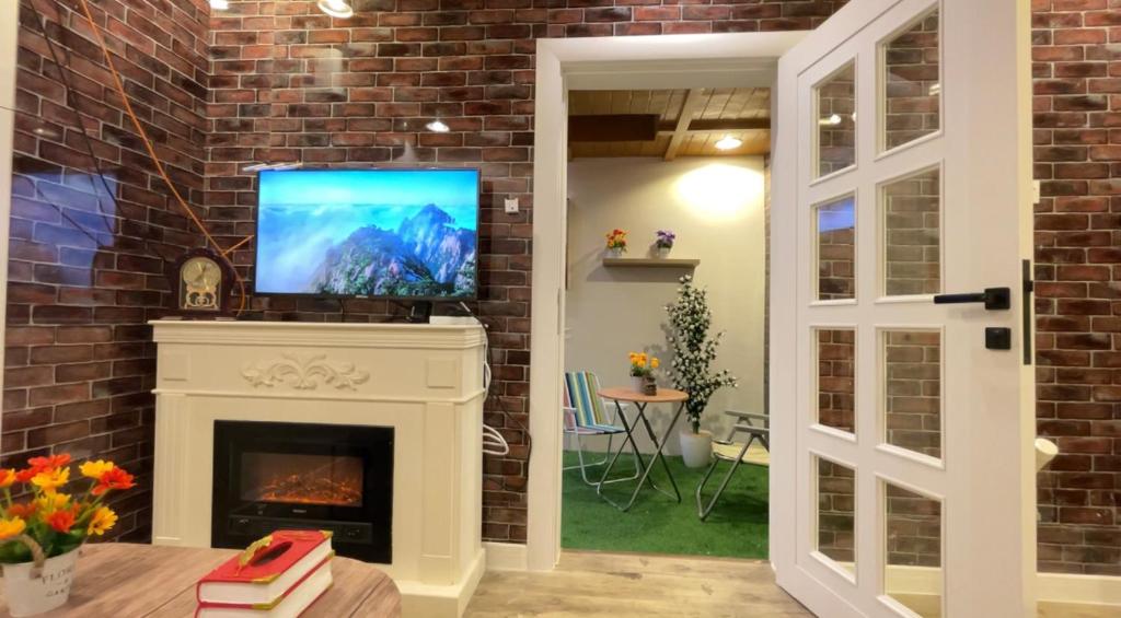 a living room with a fireplace and a flat screen tv at بيتي بلس للغرف الفندقية- مدخل مستقل in Riyadh Al Khabra
