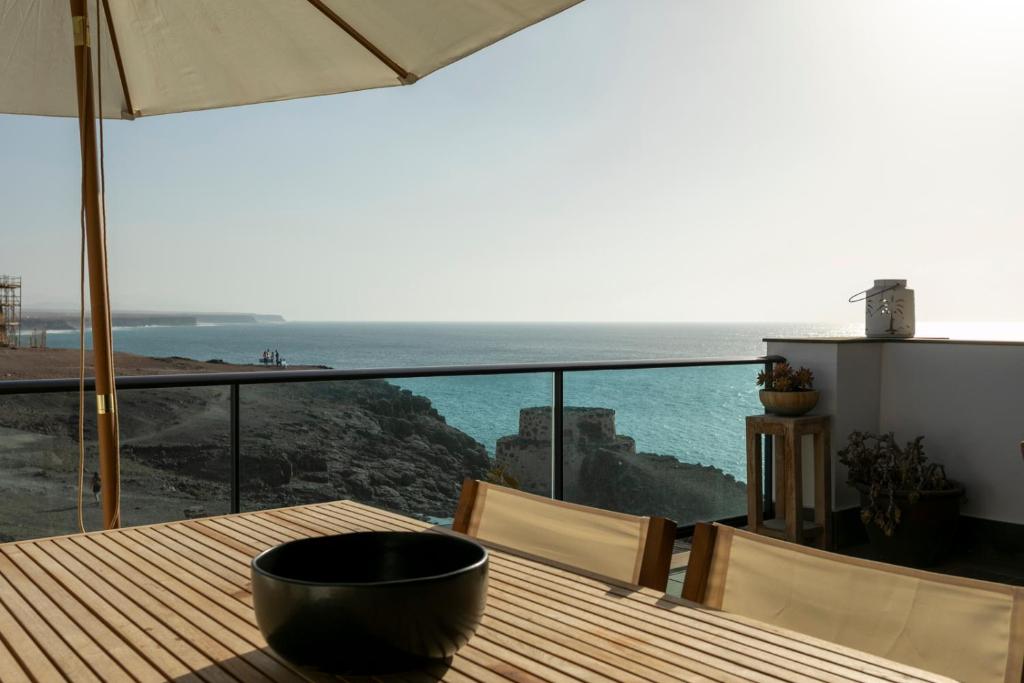 a wooden table with a view of the ocean at Apartment Mirador Del Castillo 3 El Cotillo in El Cotillo
