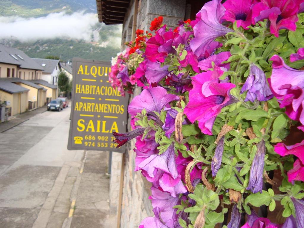 un panneau avec des fleurs sur le côté d'un bâtiment dans l'établissement Apartamentos Saila, à Castejón de Sos