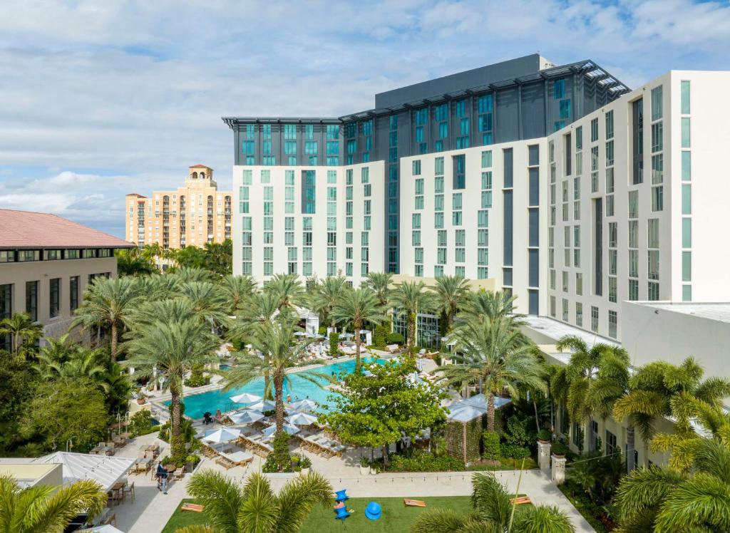 - une vue aérienne sur un hôtel doté d'une piscine et de palmiers dans l'établissement Hilton West Palm Beach, à West Palm Beach